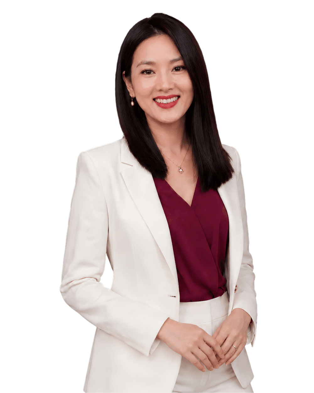 Professional headshot of a smiling woman in a white blazer and burgundy blouse, hands loosely clasped.